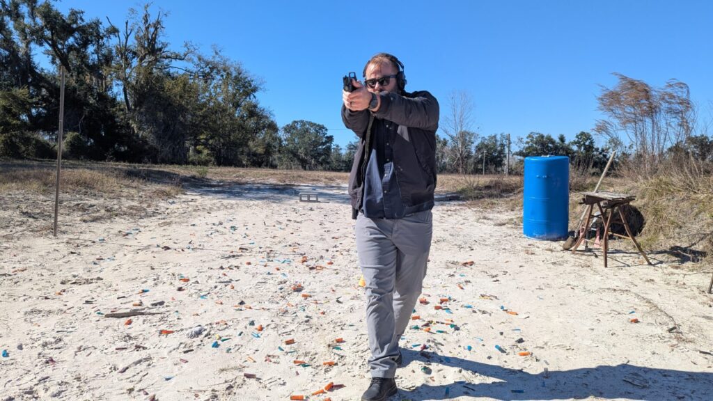 Shooter moving forward pistol aimed downrange.