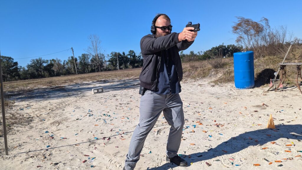 Shooter moving  laterally, pistol aimed downrange.