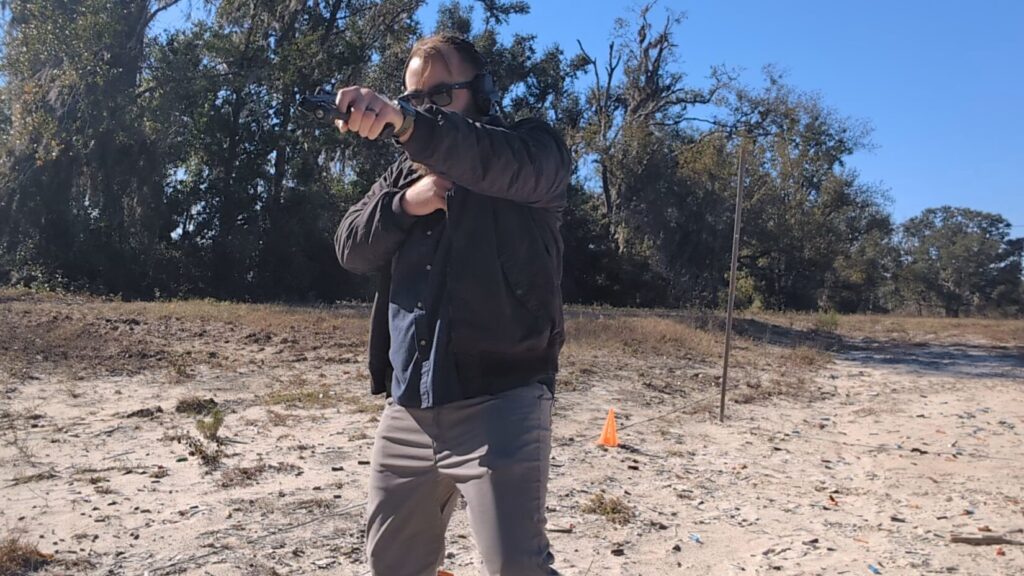 Shooter moving laterally across the range, pistol extended.