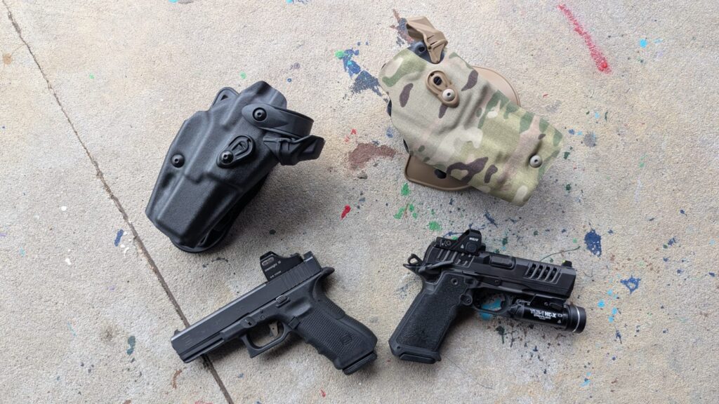 Overhead view of a Glock 17 and a Staccato HD pistol, both customized with optics and lights, on concrete.