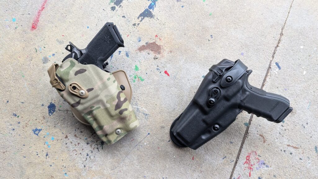 Overhead view of a Staccato HD pistol holstered in a MultiCam kydex holster and a Glock 17 pistol holstered in a black kydex holster.