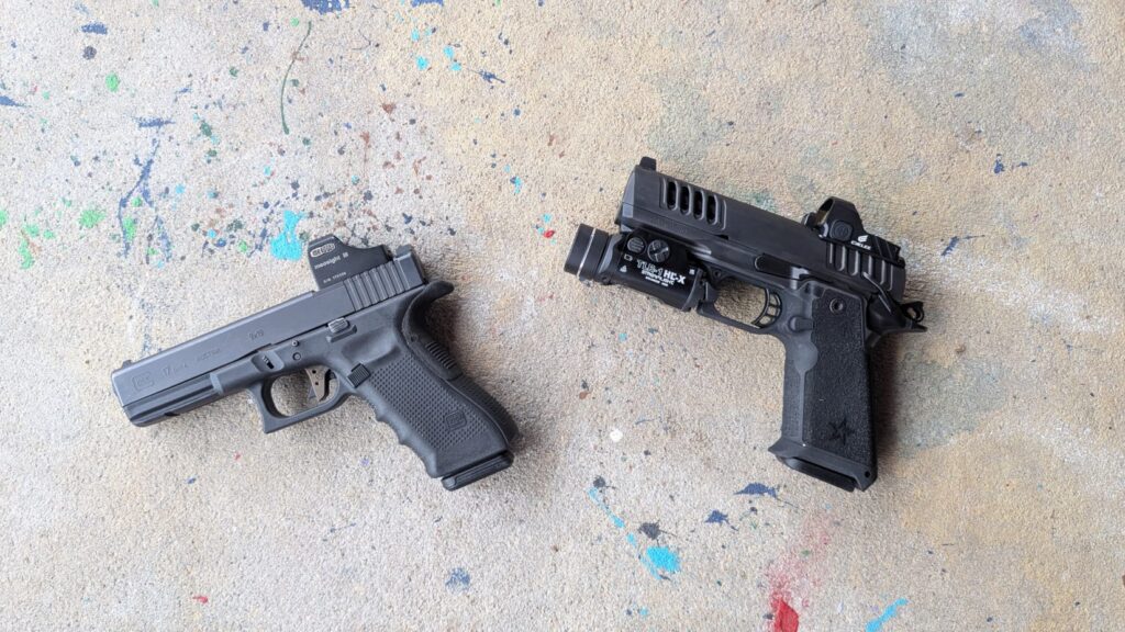 Overhead view of a Glock 17 and a Staccato HD pistol, both customized with optics and lights, on concrete.