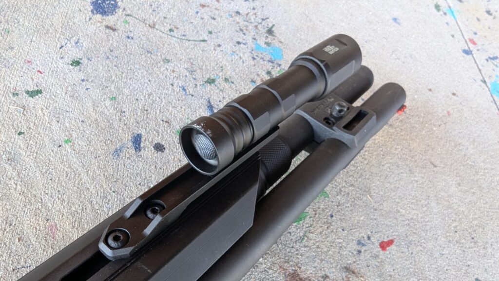 Angled close-up of the Modlite Havok attached to the shotgun barrel and forend.