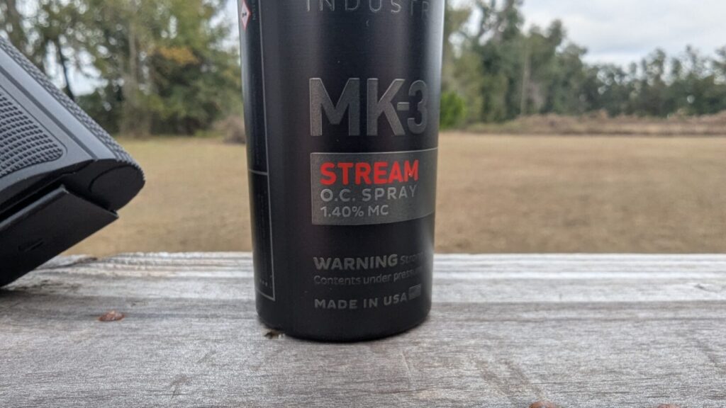 Close-up of a black POM Industries MK-3 Stream O.C. Spray canister showing the 1.40% MC label.