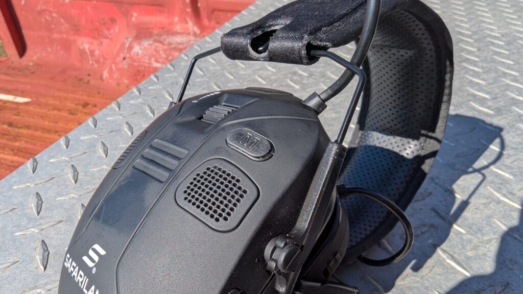 Side view of Safariland electronic ear protection cup with headband resting on a rusty red surface