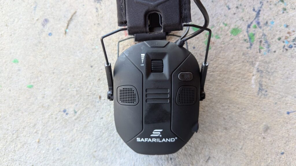 Top-down view of Safariland electronic ear protection cup, highlighting the volume dial and mode buttons.