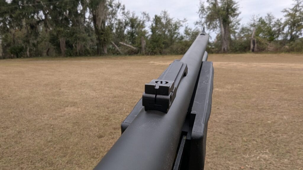 Rear iron sight view down the black shotgun barrel.