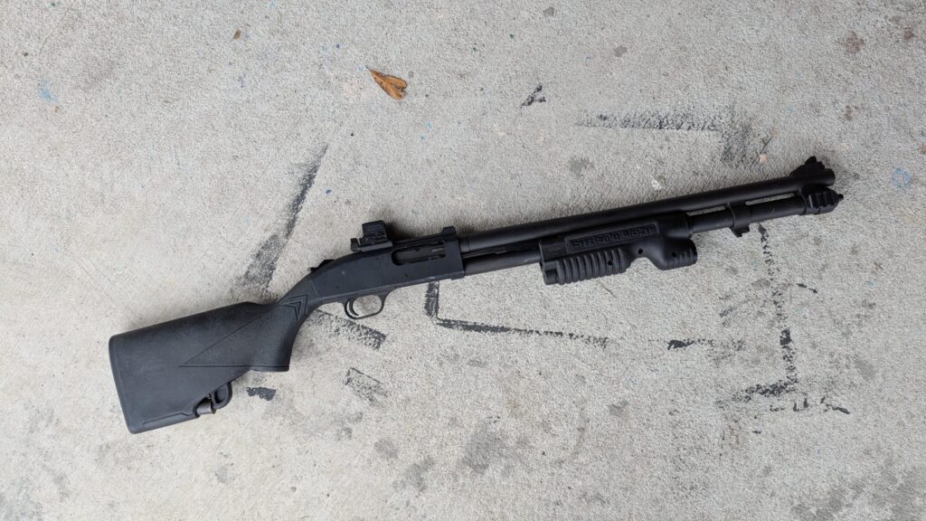 Mossberg 590 laying on concreate slab with paint markings