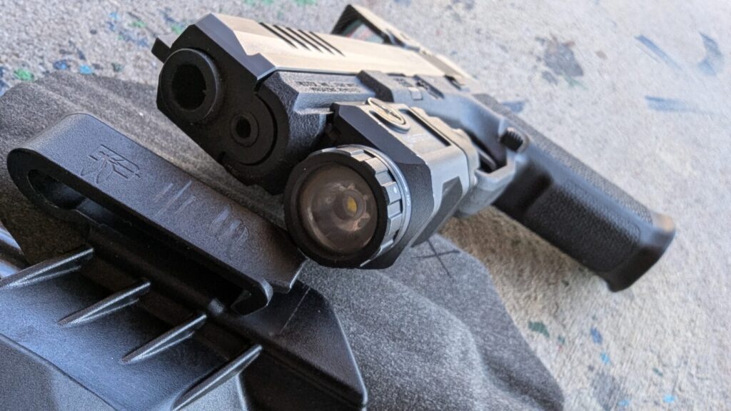 Close-up of a pistol-mounted light and a threaded barrel.