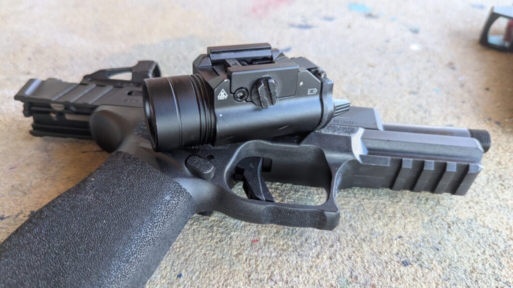 Close-up of a pistol muzzle and an attached weapon light.