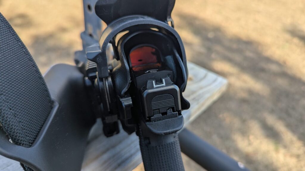 A front-profile view of the holster on a belt, emphasizing the protective hood designed for red dot sights.
