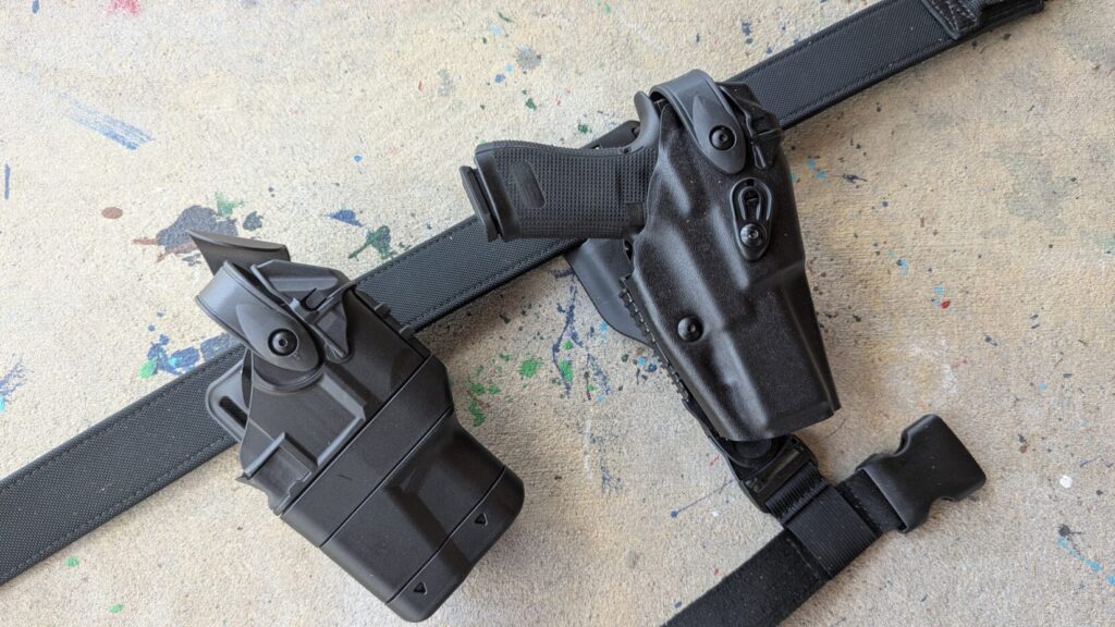 Two Safariland holsters laid on concrete; the 6360RDS with a Glock is on the left, and a similar model with a protective optic cover is on the right.