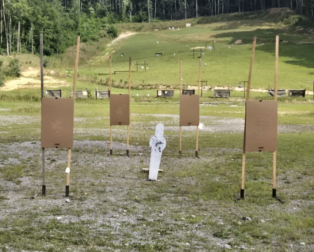 4 cardboard targets and a steel targets on a range.