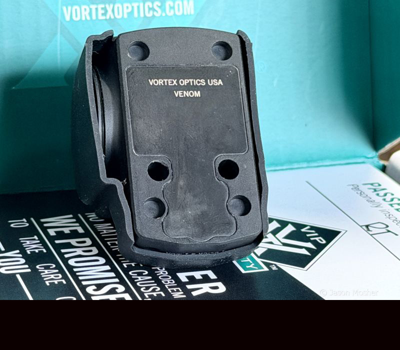 The bottom of an optic in a box, showing the mounting holes for the DPP footprint. 