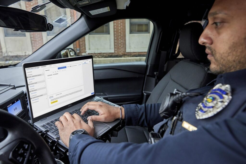 Police officer typing in patrol car