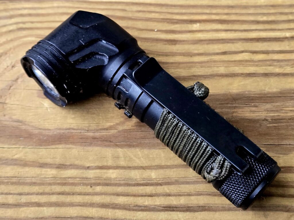 An angle head flashlight on a wooden backdrop
