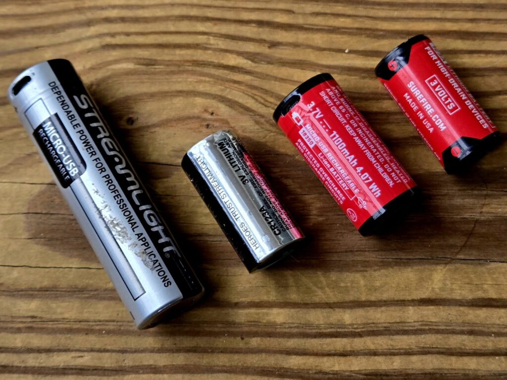 4 different types of batteries on a wooden backdrop