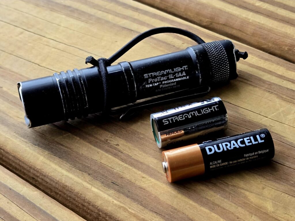 A flashlight with a CR123 Battery and AA Battery