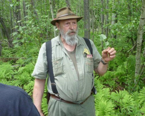 A man in green wearing suspenders on a plant walk