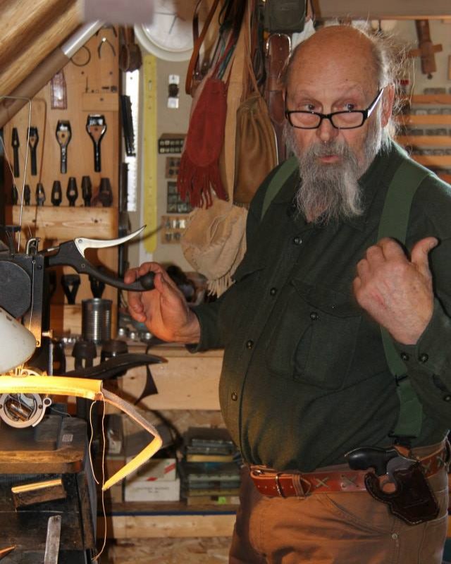 a man working in a leather shop with a revolver on his hip