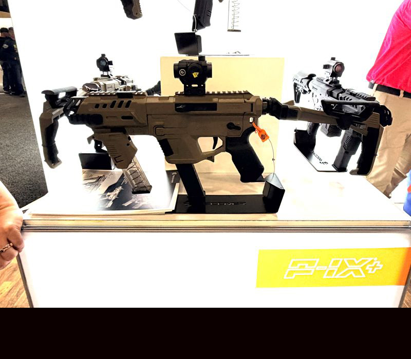 A P-IX sub-gun platform on display with other guns and people in the background.