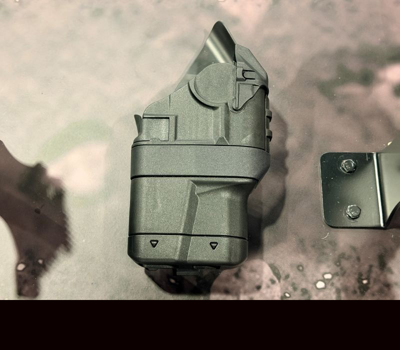 A black holster laying on a table during a product show. 