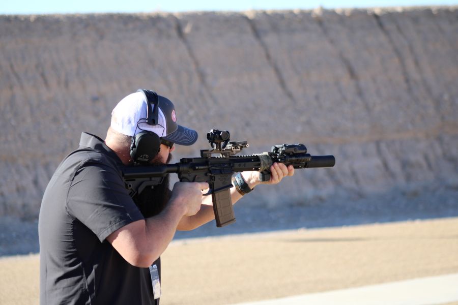 A man with a white hat and black t-shirt, shooting an AR-15 at the Staccato Range.