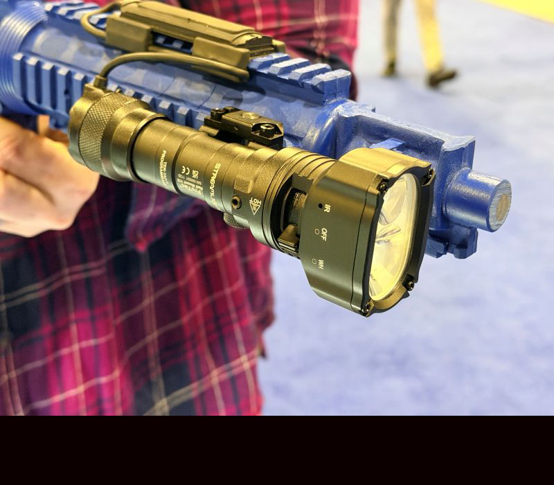 A black light mounted to a rifle with a rectangle shaped head on the light.