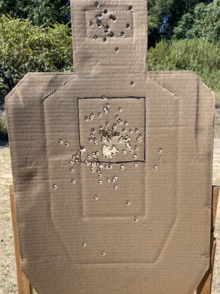 A brown cardboard IPSC target with bullet holes in it and a black box in the A zone showing where to keep your shots for best shot placement