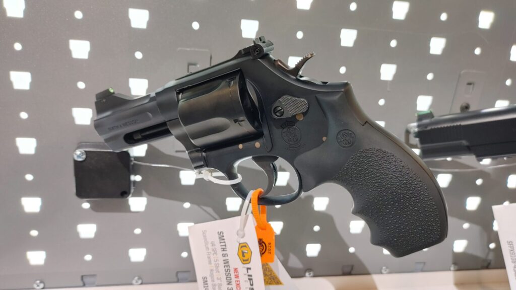 A side view of a black Smith & Wesson Model 396 revolver on a display wall with a Lipsey's product tag.