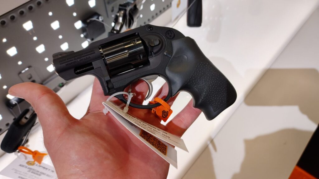 A Ruger LCR revolver with a black rubber grip held in a person's hand.