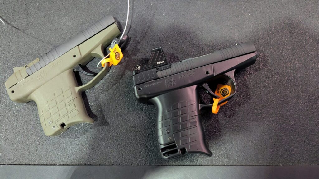 Two Kel-Tec PR 3AT pistols on a mat; one is olive drab and the other is black with a red dot sight.
