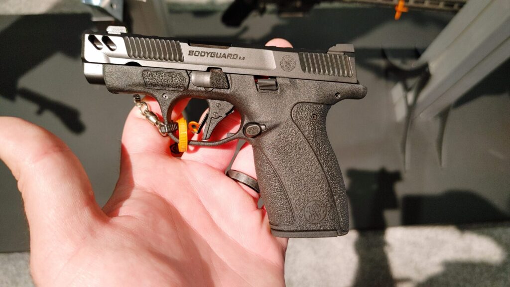 A person holding a Smith & Wesson Bodyguard 2.0 pistol, showing the side profile and texture.