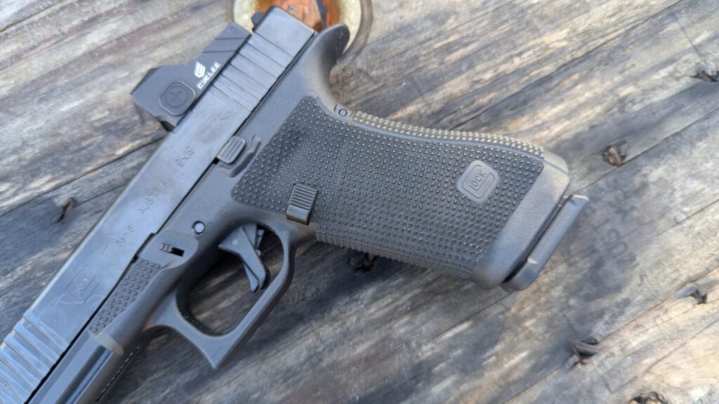 Extreme close-up of the trigger guard and grip texture of a Glock 17 Gen 6.