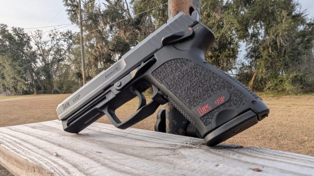 A low-angle perspective of the HK USP showing the grip texture and the red "HK USP" logo on the frame.