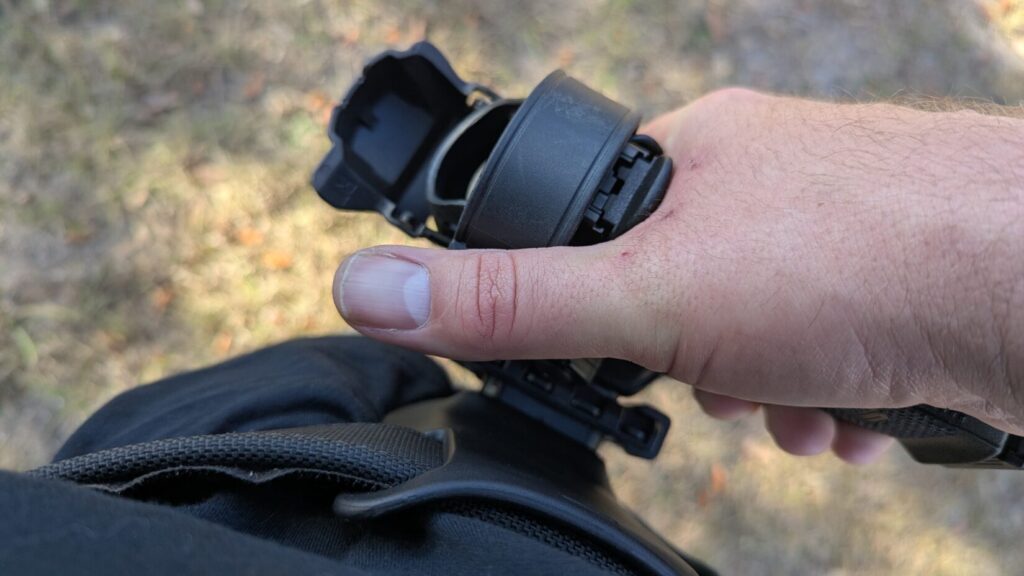 A high-angle, first-person view of a person's hand gripping a holstered handgun at their hip.