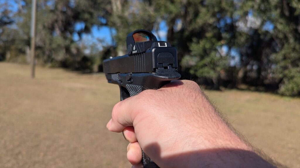 A first-person perspective (point-of-view) looking down the slide of a Glock 17 Gen 6, focusing on the rear iron sights and the Cyelee red dot optic. Poor master grip