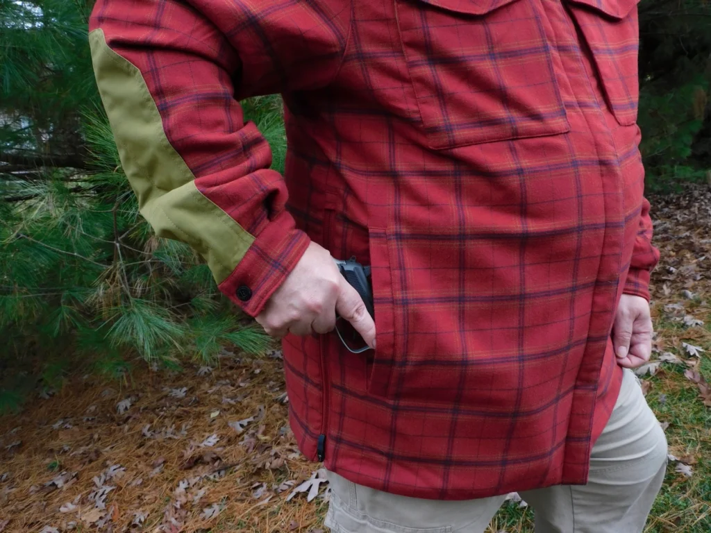 Man drawing a concealed carry pistol from his coat pocket