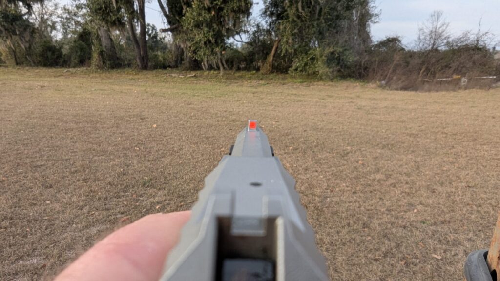 A first-person view down the slide of the Taurus 22TUC, focusing on the bright orange front sight.