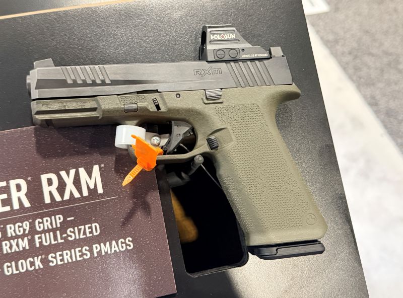 A Ruger RXM, black and green handgun on display at a gun show. 