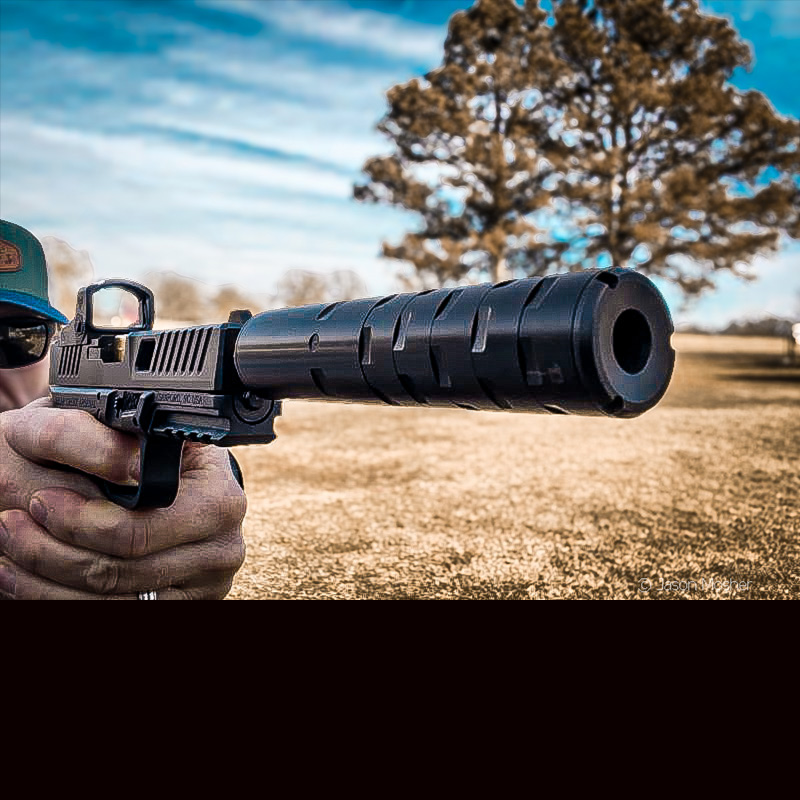 A person shooting a handgun with a silencer on it. 