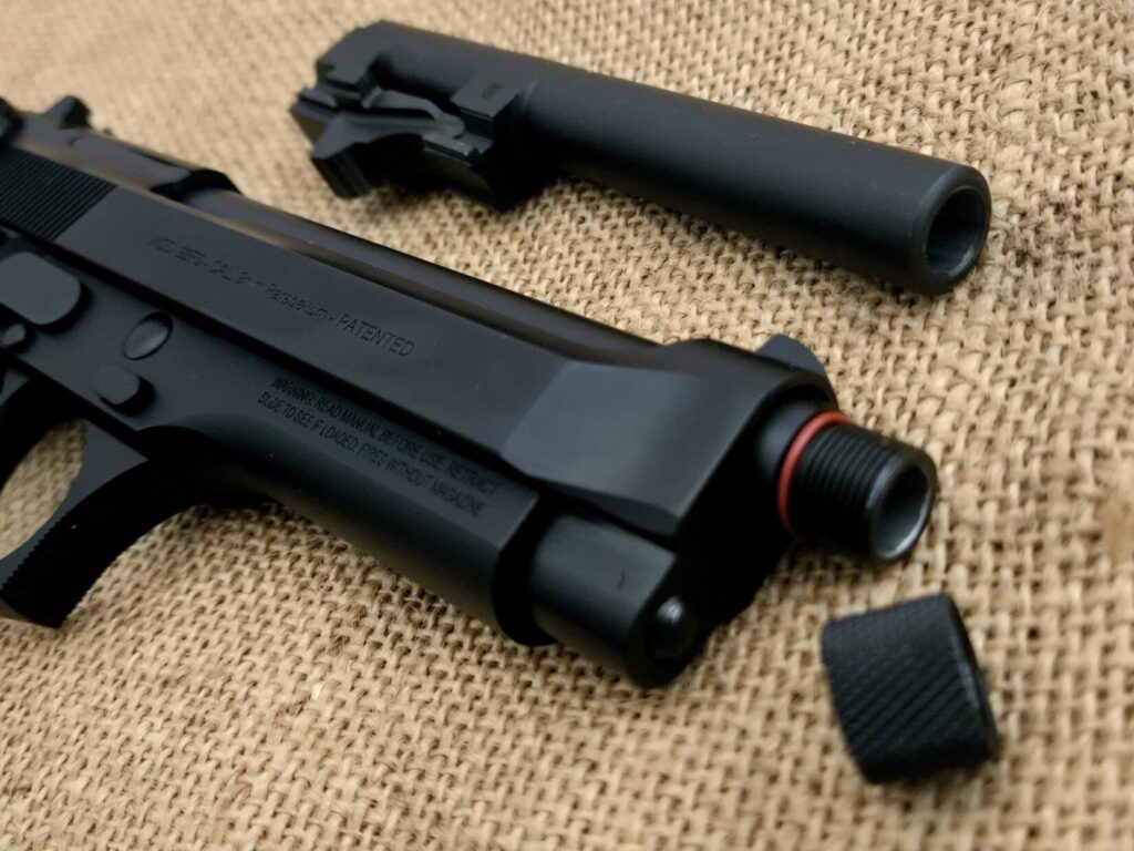 A standard Beretta 92FS barrel and a threaded barrel