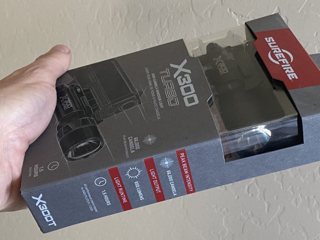 hand holding SureFire X300 Turbo weaponlight in package
