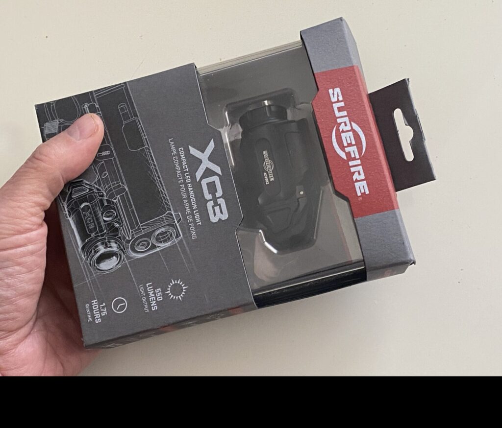 Hand holding surefire xc3 package