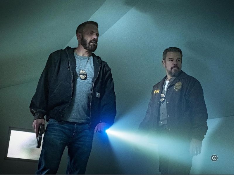 A view of two people standing in the night with flashlights in the movie "The Rip"