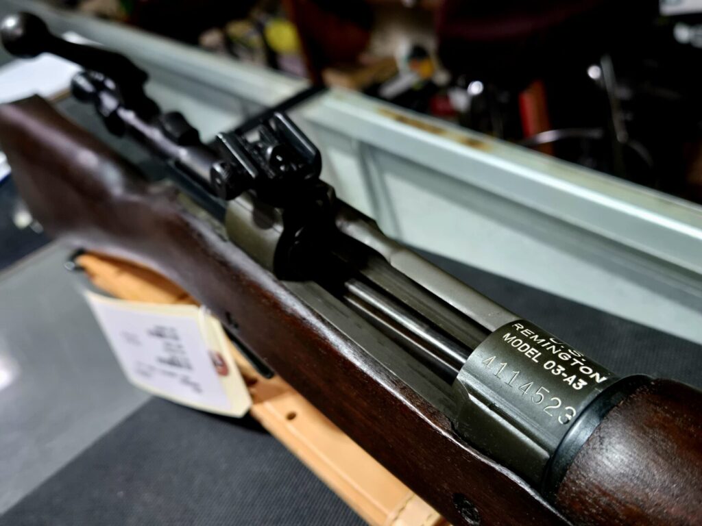 An old Army rifle on top of a glass cabinet