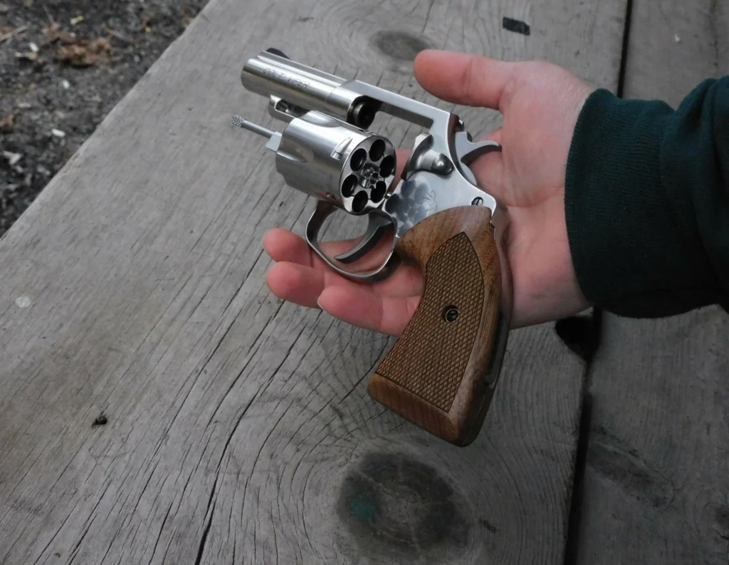 Man holding a Colt Viper revolver with the cylinder open.