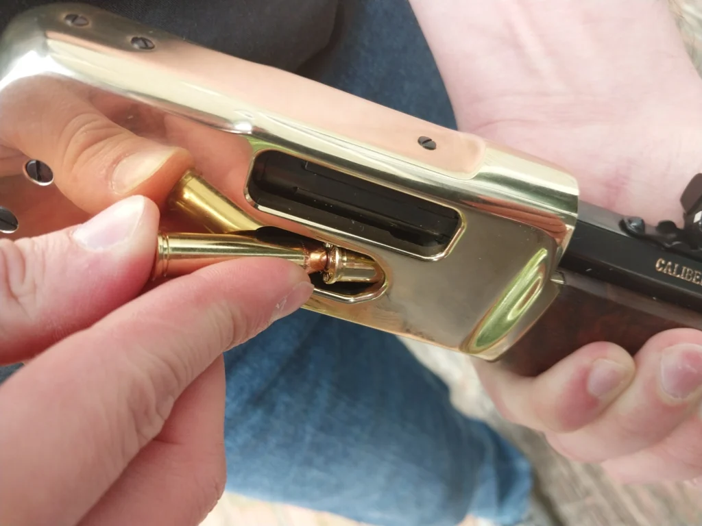 Man reloading a lever action rifle through the side loading gate