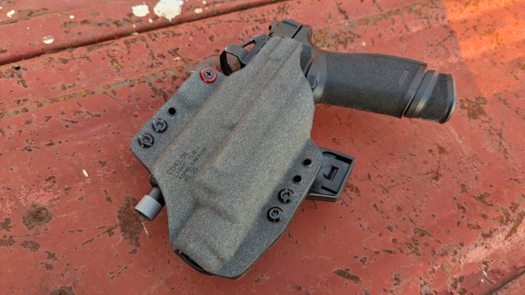 Incogx holster resting on a red surface, showing the stamped text "ECHELON LIGHT TLR-1".