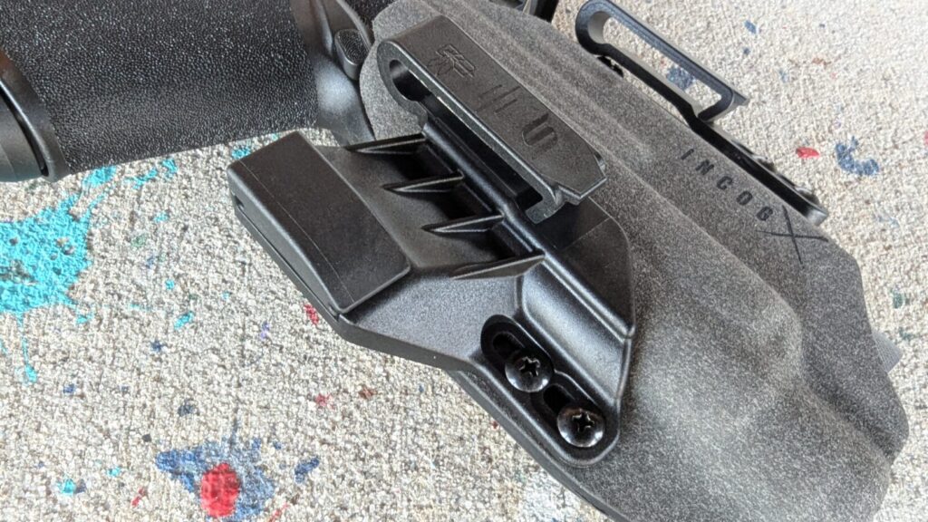 A Springfield Echelon with a red dot sight seated in a gray microfiber-wrapped IncogX holster, held to show the concealment wing.